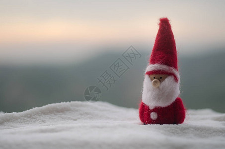 卡通可爱人物圣诞快乐圣诞老人娃与树和雪模糊的户外背景圣诞老人和圣诞快乐模型人物玩具背后的散焦自然背景背景