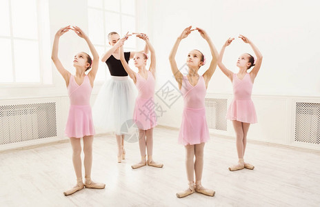 年轻的芭蕾舞老师和学生芭蕾舞演员在舞蹈课上女孩们在芭蕾舞图片