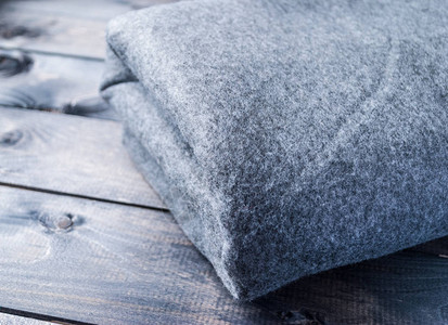 灰色毯子折叠在木凳上图片