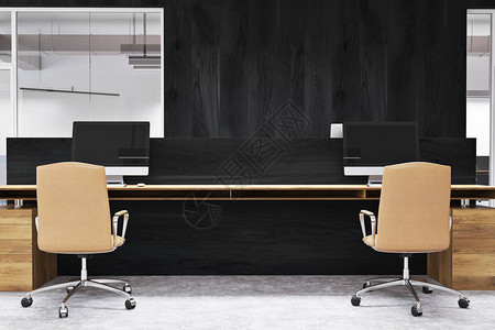 现代办公室内装有黑色墙壁白色混凝土地板和长木制计算机桌图片
