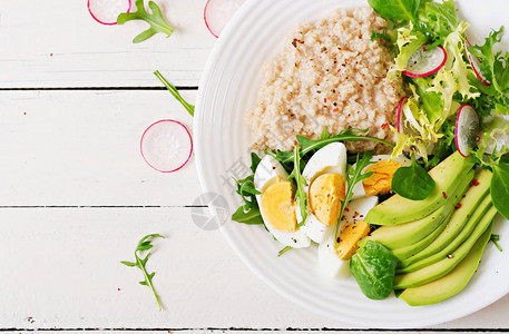 健康的早餐膳食菜单燕麦粥和鳄梨沙拉和鸡蛋顶部视图背景图片