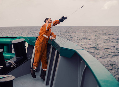渔夫在一艘船上投掷钩钓金鱼海上捕鱼图片