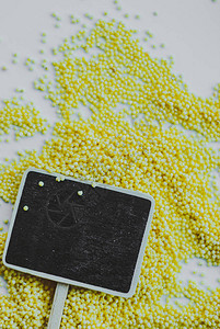 白色背景上的有机小米种子和黑板图片