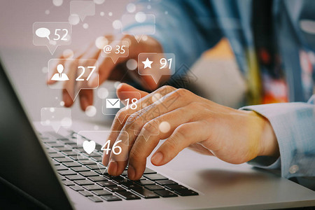 社交媒体和市场营销虚拟图标屏幕的概念商人的特写在现代办公室的木桌上用笔记本电脑打字键盘图片