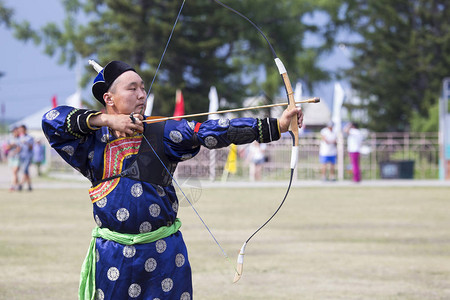 比赛在西伯利亚的体育弓蒙古射箭比赛这位运动员穿着传统的布里亚特蒙古西服在时用箭图片