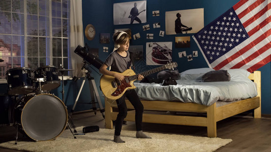 富有表现力的年轻人在卧室里弹吉他图片