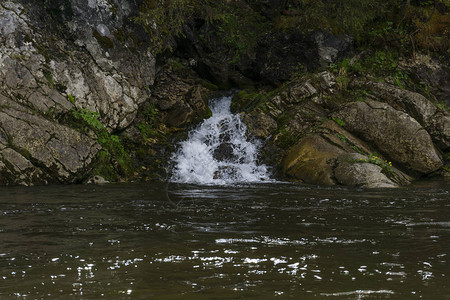 泉水沿着岩石的瀑布流进河中严禁河图片