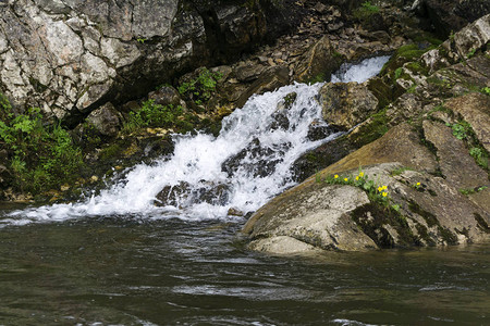 泉水沿着岩石的瀑布流进河中严禁河图片