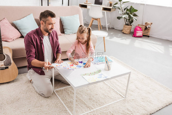 快乐的父亲和女儿在家里画画图片