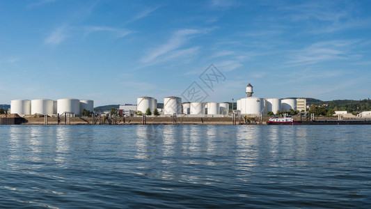储存仓石油和汽油油库在德国西部的河岸上在一个美丽的蓝天与云高分辨率全景可见油轮驳船图片