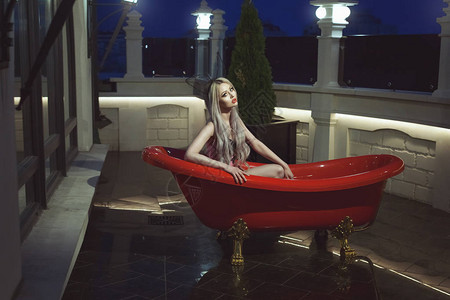 在露天的一个豪华的红色沐浴的妇女图片