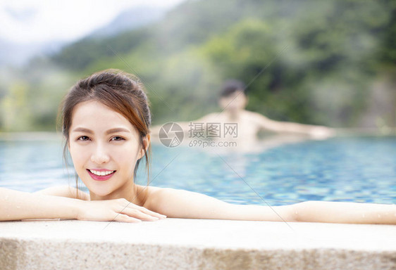 年轻的亚洲情侣在温泉放松图片
