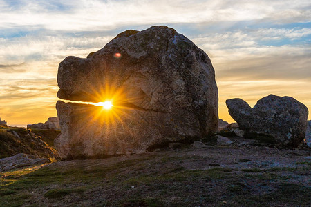 法国布列塔尼岛海岸线上一块奇怪的巨大岩石后面的日落上面有兽面和龟形石图片