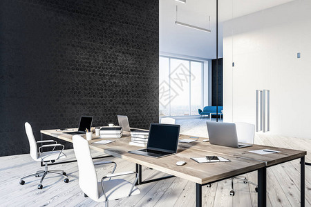 现代办公室的内部设有黑色蜂窝图案墙壁木地板四张带笔记本电脑的木桌和大堂的蓝色沙发3图片