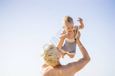 有吸引力的金发妈妈玩与4月大男婴在上图片