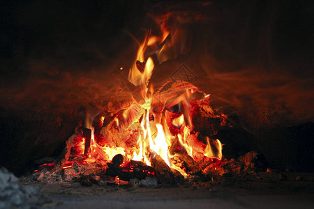 在炉子里燃烧木材木柴在农村烤箱里燃烧在壁炉特写中燃烧木柴火和火焰靠近壁炉里燃烧的木柴图片