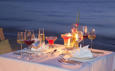 轮廓玻璃的葡萄酒和设备在木制桌子上海景和天际线在晚上与日落色调风格图片
