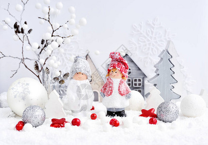 圣诞节装饰小人物男孩和女孩与节日装饰在雪地里圣诞或贺卡图片
