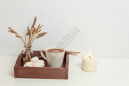 天然生态家居装饰与杯咖啡棉花糖烛在木制托盘清晨早餐生活方式背景室内装饰与热饮杯斯堪的纳维亚风格的复制空间图片