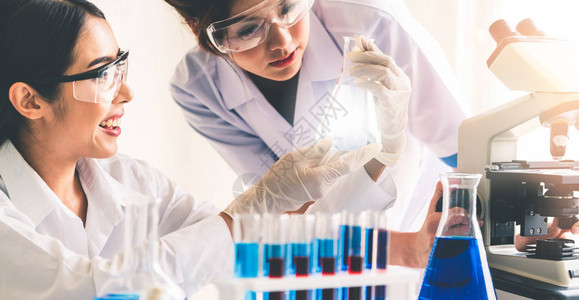 一组科学家穿着实验室外套在实验室工作同时检查试管和科学仪器中的生物化学样品科学技术研发研究理念图片