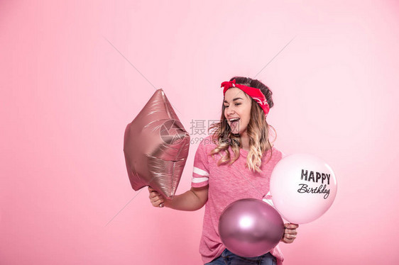 带着气球的粉红T恤有趣的女孩生日快乐在粉红色背景上笑容和情感派对和节日的概图片