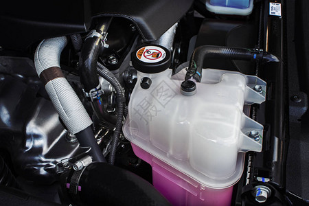 带有粉红色液体防冻液的散热器系统的冷却液箱图片