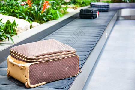 传送带上的手提箱在机场行李提取区被绿色图片