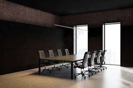现代会议室的角落有黑色和砖墙混凝土地板阁楼窗户和带椅子的黑色桌子图片