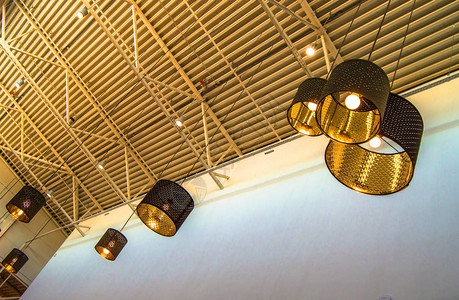 现代风格的铜质装饰灯和金色灯罩挂在长绳工业天花板图片