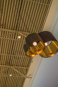 现代风格的铜质装饰灯和金色灯罩挂在长绳工业天花板室内设图片