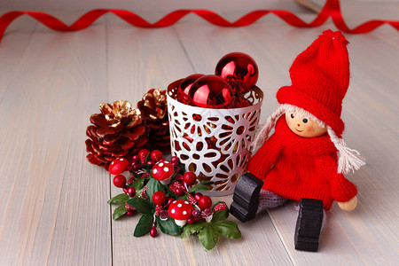 圣诞或作文与节日装饰坐在木制背景上的小男人形象与圣诞球和松图片