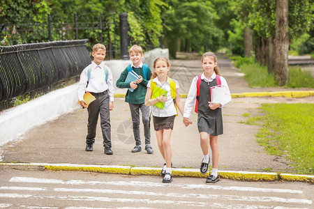 可爱的小学生在户外横穿马路图片