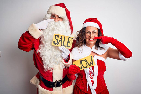 穿着圣诞老人服装的情侣在孤立的白色背景上举着华丽和销售横幅图片