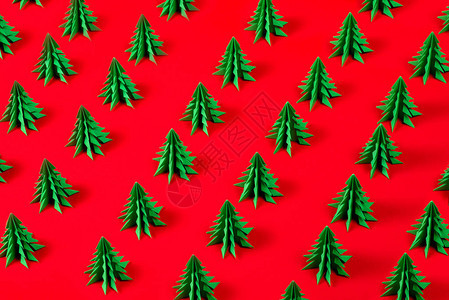 冬季快乐假期的假期背景用折纸制作的绿色枞树在假日红色背景下的镜头贺卡图片