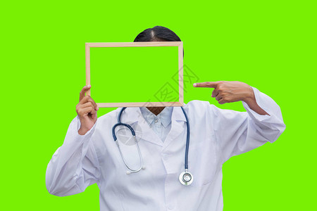 专业女医生在白色孤立的背景和指向绿色空白板的白大褂医疗保健科学和医图片