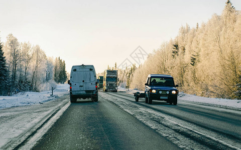 芬兰冬季路上有雪的迷你面包车拉普兰的汽车和寒冷的风景欧洲森林芬兰城市公路骑行道路和线下雪的街背景图片
