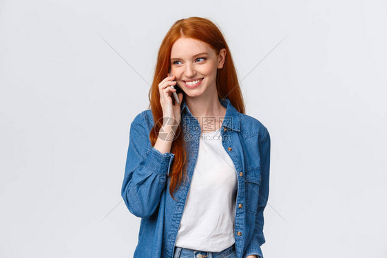 打电话给男朋友的女孩下课后接她迷人外向的红发女人在电话里聊天无忧无虑地微笑着在智能手机上随意交谈白色背景图片