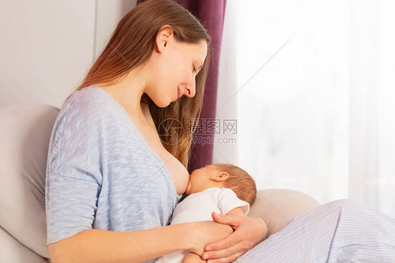 开心微笑的妈妈给刚出生的男孩喂奶图片