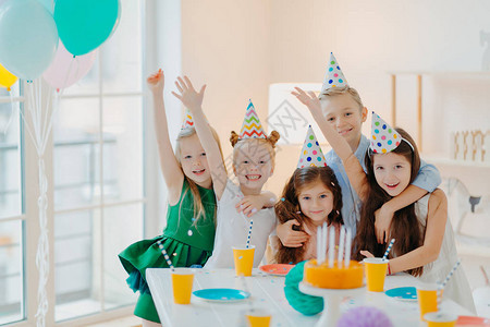 儿童聚会和庆祝概念一群小朋友在一起合影高举双臂开心地微笑举办生日聚会活动无所事事背景图片