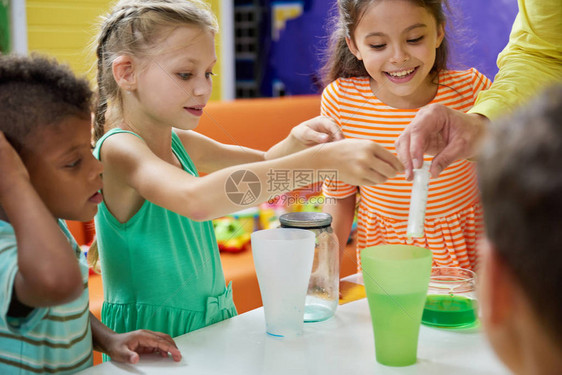 孩子们在娱乐中心做化学实验餐桌上有丰富多彩的液体的瓶子儿童派对娱图片