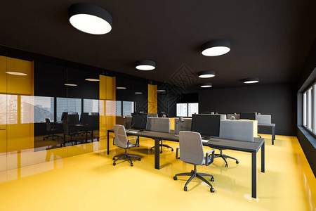 以黑色墙壁明亮黄色地板和几排计算机台站窗边的市风景相近的电脑桌为中心图片