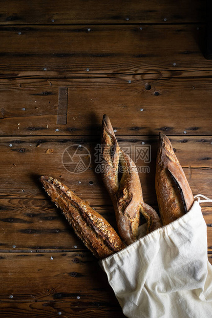 选择法国面包在木本底面包袋中挑选面包图片
