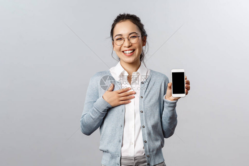 在线概念和移动生活方式快乐自夸的亚洲女在应用程序智能手机显示屏上展示图片或个人资料开心地拿着手机笑着笑着相机图片