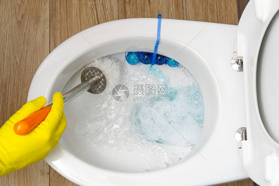 男人打扫厕所在厕所当清洁工的管家打扫一下厕所保持清洁卫生清洁马桶清洁服务理念图片
