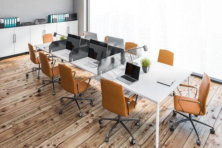 开放空间办公室的顶视图有灰色墙壁木地板带橙色椅子和白色文件柜的白色大电脑桌背景图片