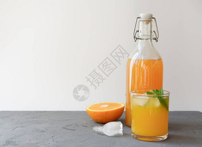 橙汁在瓶子和杯子中图片