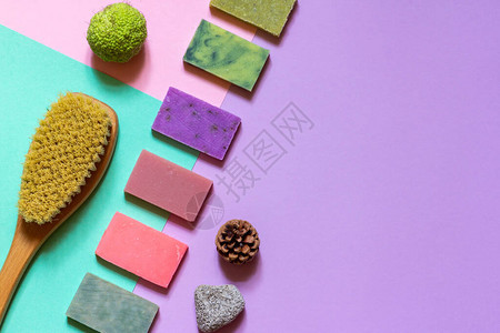 彩色天然手工制肥皂干按摩刷和天然花粉紫绿色背图片