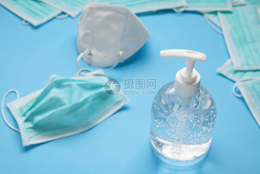 KN95在蓝色背景covid19Corona预防概念上用酒精洗涤剂凝胶洗手图片