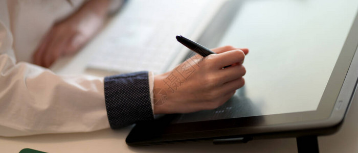 笔和笔记本在工作空间利用数字平板电脑对年轻背景