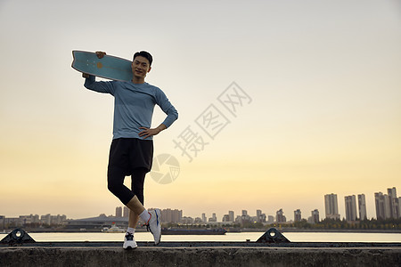 夕阳下的滑板男青年图片